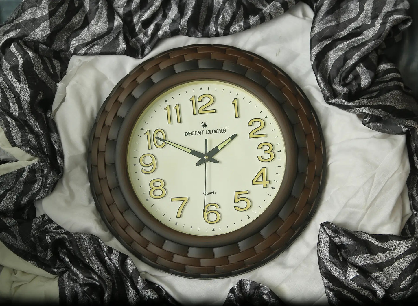 Round wall clock with wooden frame on a white surface with zebra print fabric
Cream_Brown_Glowing_wall-clock– Large 
