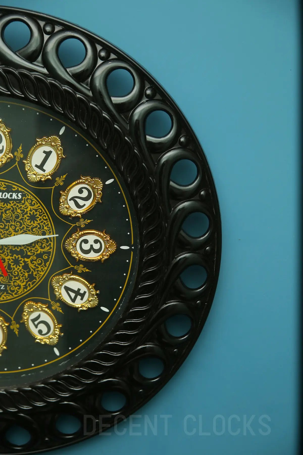 Decorative clock with black frame and gold numbers on a blue background