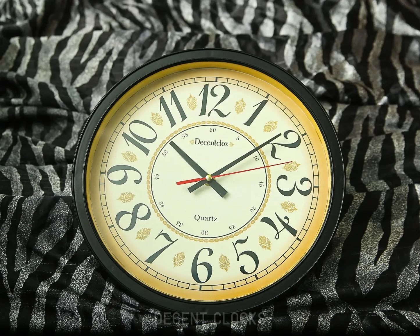 Round wall clock with black frame and white face on a patterned fabric background